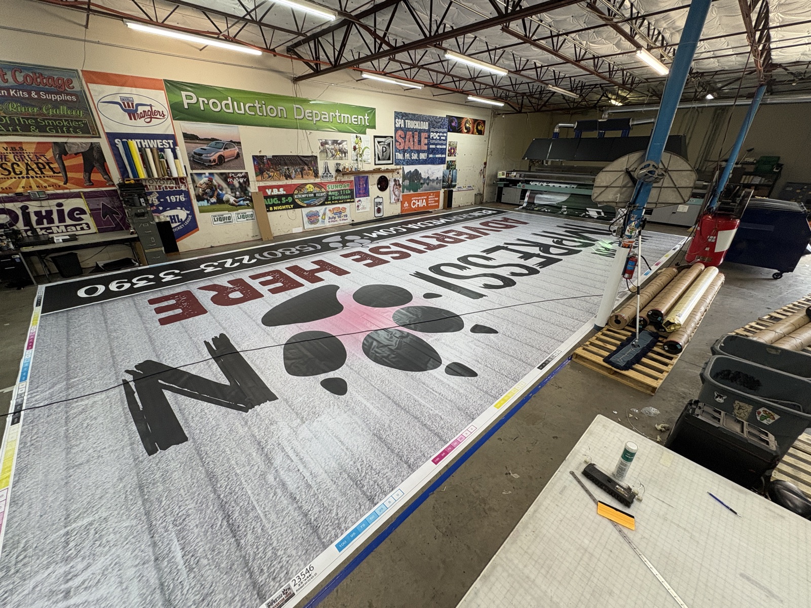 Large billboard graphic displayed across the production floor